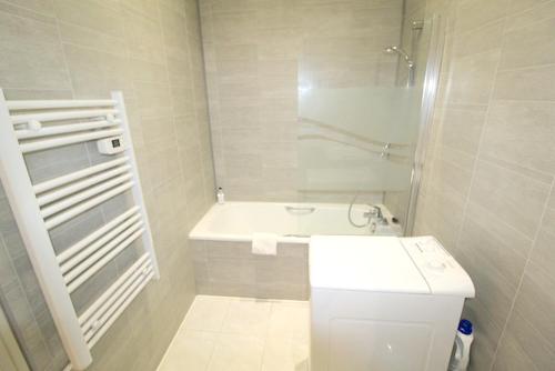 une salle de bain avec un lavabo et une baignoire dans l'établissement Appartement confortable à Cannes avec climatisation - 53 m², à Cannes