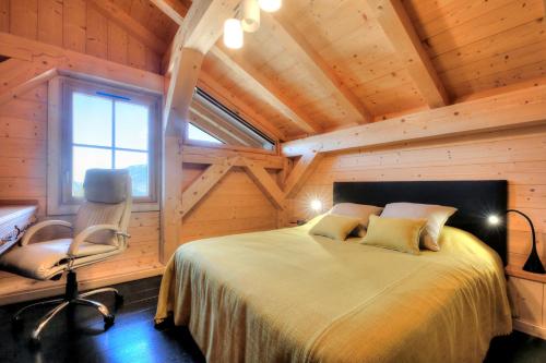 - une chambre avec un lit et une chaise dans l'établissement IMMOBILIER DE MONTAGNE - LA COLLECTION - CHAMPETRE, à Saint-Gervais-les-Bains
