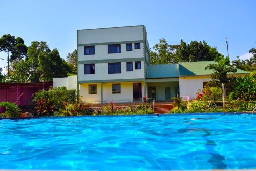 a house from the water in front of a swimming pool at The Adrace Exec. Hotel in Kampala