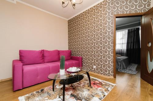 a purple couch in a living room with a table at ERA RENT Apartments in Chişinău