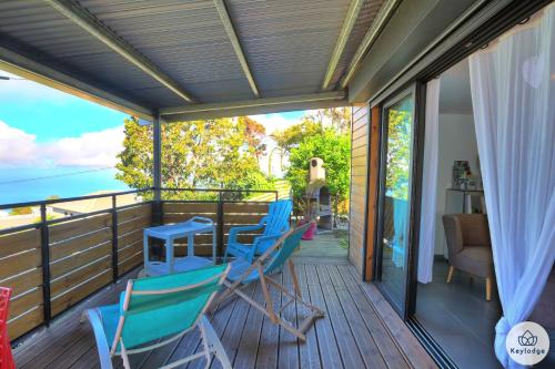 a deck with blue chairs and a table on it at Les Gites Le Bambou - 3 étoiles - Les Avirons in Les Avirons