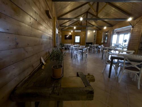 a dining room with tables and chairs and a wooden wall at Baita Pavò in Trivento