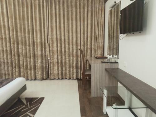 a room with a bed and a desk and a mirror at Hotel Udayanraje Palace in Ahmadnagar