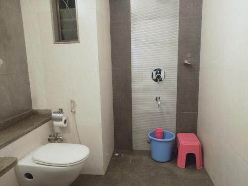 a bathroom with a toilet and a red stool at Hotel Udayanraje Palace in Ahmadnagar