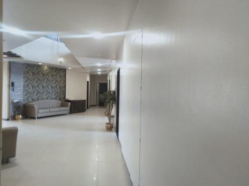 a living room with a white wall and a couch at Hotel Udayanraje Palace in Ahmadnagar