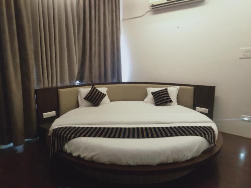 a large bed in a room with a window at Hotel Udayanraje Palace in Ahmadnagar