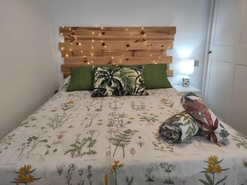 een slaapkamer met een groot bed met een houten hoofdeinde bij Loft Tulipanes Amarillos Junto a la Mezquita in Córdoba