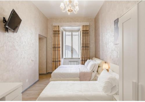 una camera da letto con due letti e un lampadario di Rome Place a Roma