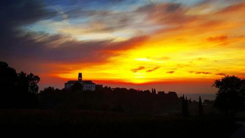 a sunset with a building on top of a hill at Pie Castello in Susegana