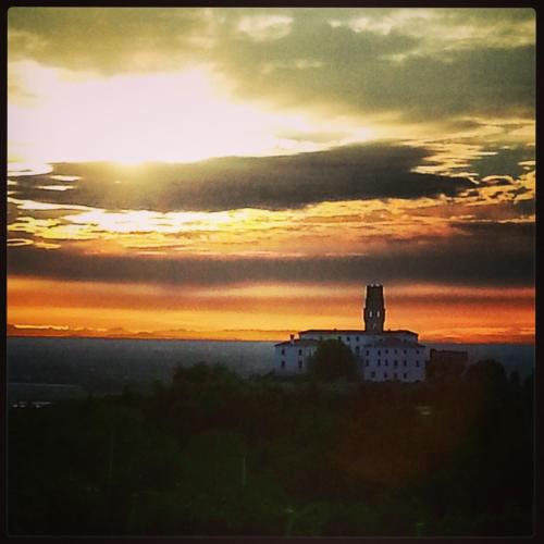 a sunset with a building with a tower in the sky at Pie Castello in Susegana