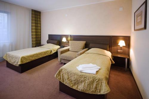 
a hotel room with two beds and two lamps at Atrium in Vologda
