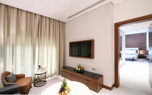 a living room with a couch and a television at Golden Tulip Riyadh Convention and Exhibition Center in Riyadh
