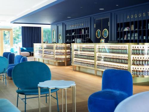 ein Geschäft mit blauen Stühlen und Flaschen Wein in der Unterkunft Jugend- und Familienhotel Augustin in München