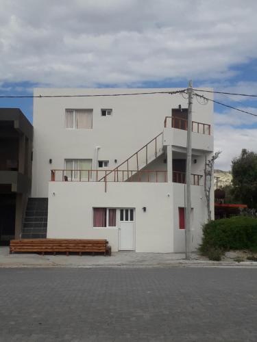 a white building with a staircase on the side of it at Alojamiento Goos in Puerto Pirámides
