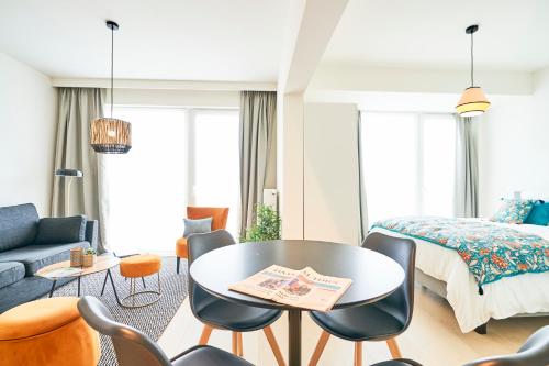 een slaapkamer met een bed en een tafel en stoelen bij Diamant Studio in Brussel