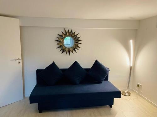 ein blaues Sofa im Wohnzimmer mit Spiegel in der Unterkunft Souterrain Zimmer mit separatem Eingang und Bad in Düsseldorf