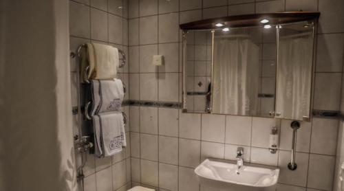 ein Bad mit einem Waschbecken und einem Spiegel in der Unterkunft Hotel Örgryte in Göteborg