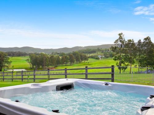 a hot tub with a view of a golf course at Marrowbone Mountain Views in Pokolbin