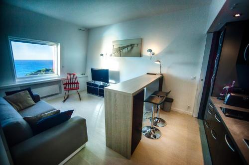 - un salon avec un canapé et un bureau avec une fenêtre dans l'établissement Les Echappées Belles - Studio du phare, à Biarritz