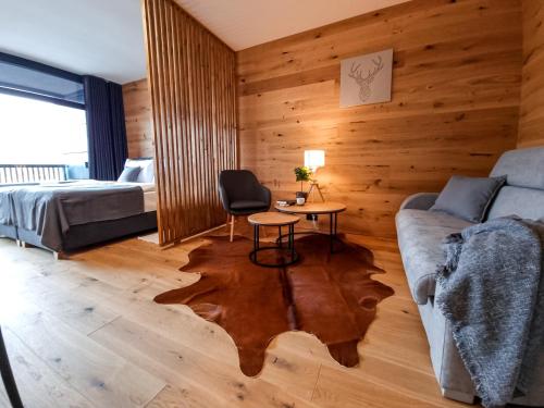 a room with a bed and a couch and a table at Tee House Čeladná in Čeladná
