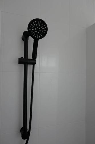 a black fan on a white wall at Baan Suandao Wat Arun in Bangkok