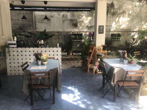 a restaurant with two tables and chairs in a patio at Baan Suandao Wat Arun in Bangkok