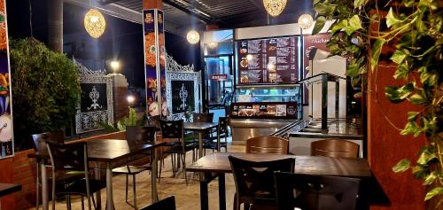 un ristorante con tavoli e sedie in legno e un bar di CTC Receptions a Anuradhapura