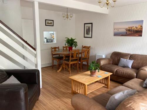 a living room with a couch and a table at Cosy coastal home - 5 mins walk from the beach in Horton