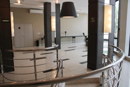 a lobby with a glass table and columns in a building at Samba Tres Rios in Três Rios