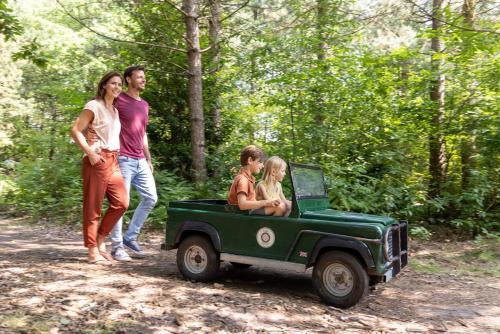 a group of people riding in a green jeep at Sunparks Kempense Meren in Mol