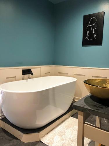 una grande vasca da bagno bianca seduta in bagno di Cambrian House B & B a Carno