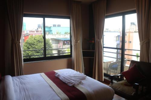 a bedroom with a bed and a large window at Hotel Family Ties Pvt. Ltd. in Kathmandu
