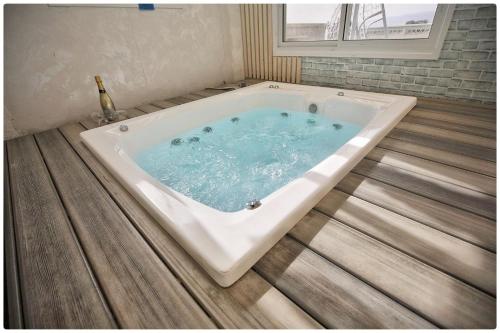 a jacuzzi tub in a bathroom with a wooden floor at סוויטת אדל in Bet Sheʼan