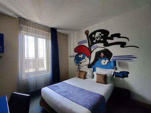 a bedroom with a bed with a mural on the wall at The Originals Boutique, Hôtel de l'Univers, Montluçon in Montluçon