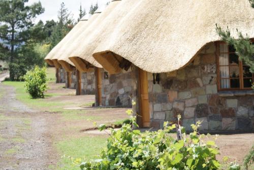 a small stone building with a thatched roof at La La Nathi Country Guesthouse in Harrismith