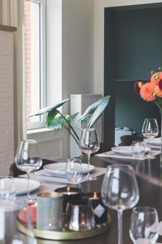 a table with wine glasses and plates on it at So'House Manor in Spa