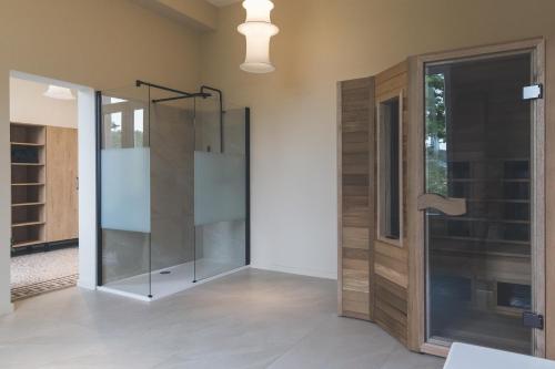 a glass shower in a room with a glass door at So'House Manor in Spa