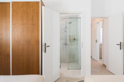 a bedroom with a glass shower and a bed at Villa Thetis Sfakia in Sfakiá