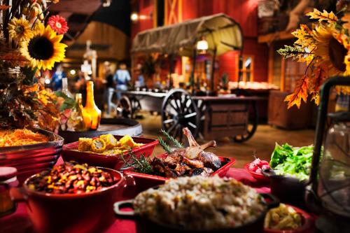 a table topped with dishes of food next to a wagon at Disney Hotel Cheyenne in Coupvray