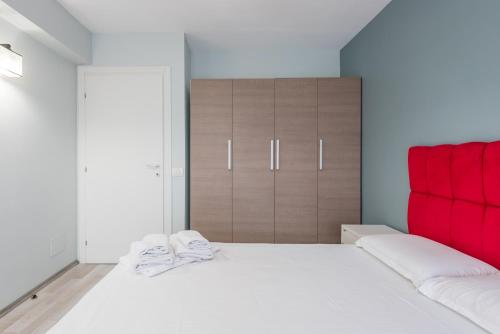 a bedroom with a large white bed with red accents at Downtown Accommodation in Bucharest