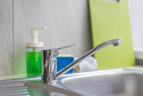 a bathroom sink with a faucet and a mirror at Downtown Accommodation in Bucharest