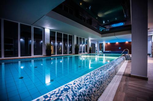 a swimming pool in a hotel at night at Hotel Moran & SPA in Powidz