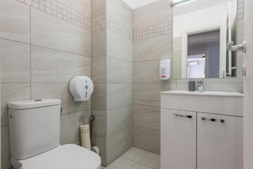 a bathroom with a toilet and a sink and a mirror at Downtown Accommodation in Bucharest