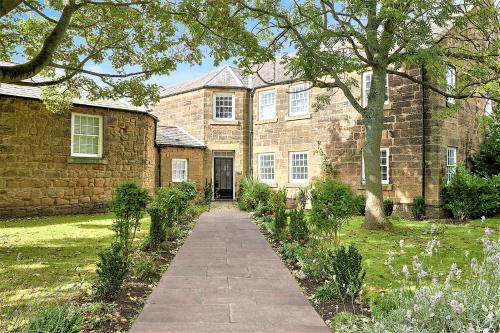 a brick building with a walkway in front of it at Host & Stay - The Old Workhouse in Alnwick