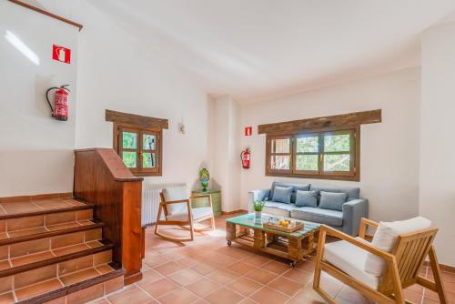 ein Wohnzimmer mit einem Sofa und einem Tisch in der Unterkunft Masia Ventanell Luxury villa near Barcelona in Llacuna