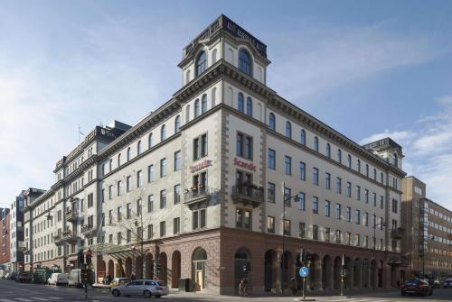 a large white building with a clock tower on a street at Scandic Grand Central in Stockholm