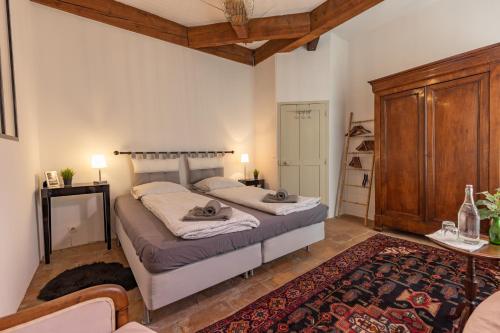 a bedroom with two beds and a wooden cabinet at Les Chambres du Lavoir Vert in Tourbes