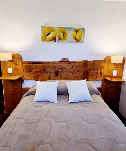 a bedroom with a bed with two pillows at Hotel La Cumbrecita in La Cumbrecita