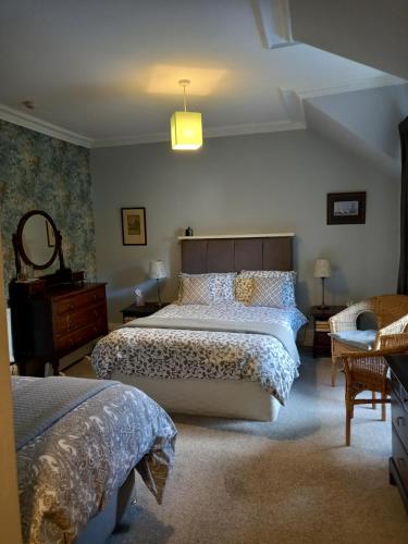 a bedroom with two beds and a mirror at The Tushielaw Inn in Selkirk