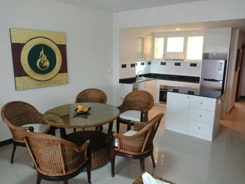 a kitchen with a dining room table and chairs at Sandy Home in Ban Thai Don (2)